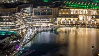 夜间鸟瞰市中心ancing喷泉市中心和一个人造湖时间推移在迪拜，阿联酋。