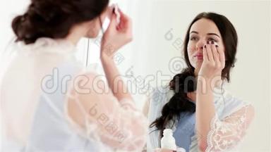 在镜子前用棉签清洁面部，迷人的女人涂上洁肤补品