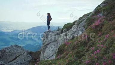 年轻女子穿着休闲装，背着背包站在高高的山崖边上，环顾四周