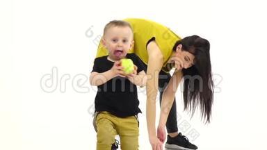 一个手里拿着苹果的孩子，从他妈妈身边跑掉了。 白色背景。 慢动作
