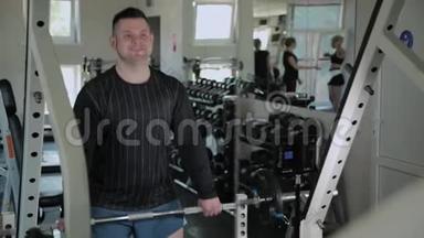 超重的成年男子在健身房进行举重。