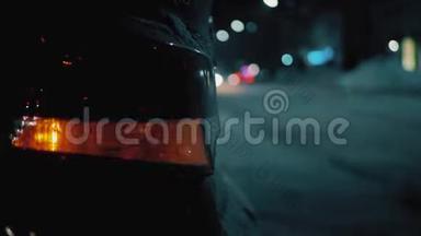 在夜间道路城市移动汽车的背景上的紧急汽车警告灯。 冬季道路交通车辆故障