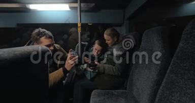 妈妈，<strong>爸爸</strong>和儿子晚上乘公共汽车，用手机