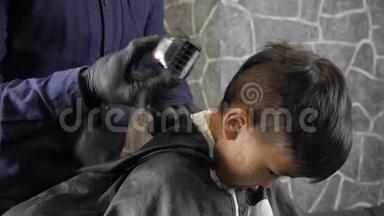 戴着黑手套的理发师把亚洲小孩的后脑勺剃成60<strong>英尺</strong>高