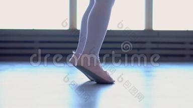 小芭蕾舞演员在一所芭蕾舞学校工作。 小女孩在学校跳舞。 芭蕾舞女演员的腿靠近。