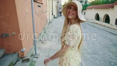 微笑的女人走在街上。 穿着白色帽子的开朗漂亮的女人在城里散步时回头看相机。