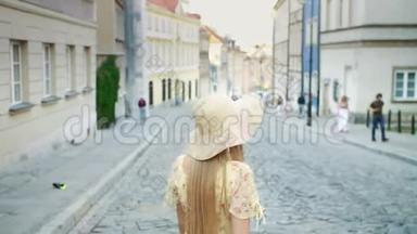 微笑的女人走在街上。 穿着白色帽子的开朗漂亮的女人在城里散步时<strong>回头</strong>看相机。