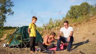 一个有孩子的小家庭在火灾周围取暖，夏天在大自然上<strong>搭帐篷</strong>