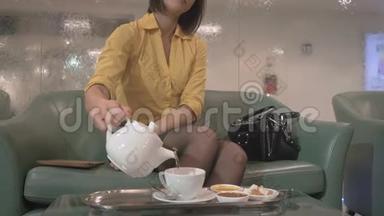 那个女孩在旅馆的喷泉附近<strong>吃饼干</strong>喝茶