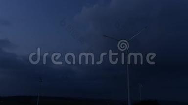 剪影式风力涡轮机农场，覆盖着黄昏的天空和白云。 旋转风力发电厂时间表