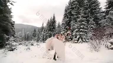新郎在雪地里旋转着快乐的新娘，手里握着她，在雪地里旋转着冷杉林