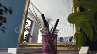 房间镜子附近桌子上化妆用的一套刷子。 化妆室桌子上的化妆刷。 专业化妆