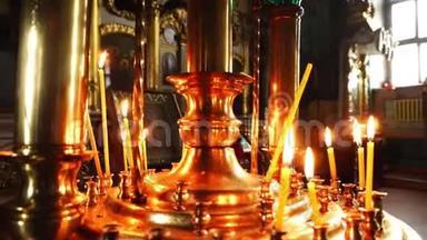 在教堂的金色吊灯上点燃蜡烛.. 东正教教堂的视频特写。