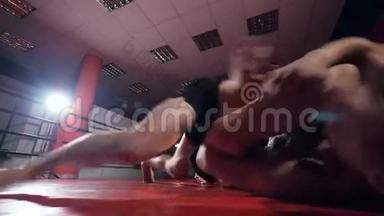 MMA战斗机在黑暗中在擂台上打斗。 慢动作，稳定射击。
