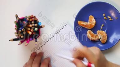 一个吃普通话的人躺在茶碟上。 然后他拿起一支笔，思考在笔记本上写什么。 从上面看。
