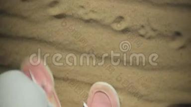 这位女士穿着闪亮的运动鞋，双腿`近距离拍摄，她慢慢地踩在潮湿的沙子上，可能在大海旁边，或者