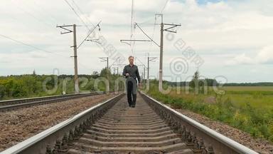 一个忧郁的人沿着铁轨走着