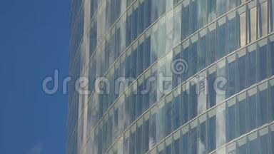 现代多层建筑窗户玻璃中明亮的蓝天倒影