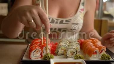 日本人吃，女孩子手拿棍子把<strong>寿司</strong>蘸<strong>酱油</strong>在餐馆里
