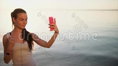 年轻漂亮的<strong>女人</strong>用她的智能手机做自<strong>拍照片</strong>。