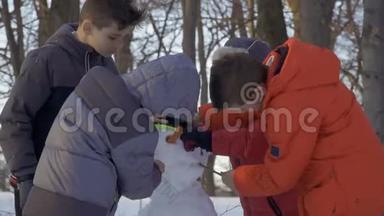 冬季公园里的男孩在慢动作地堆雪人