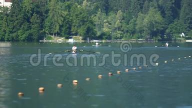三个强壮的人在美丽的湖上划船，水上运动和训练