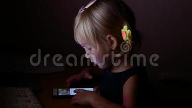 一个小女孩在<strong>看</strong>视频。 晚上，孩子<strong>看手机</strong>屏幕