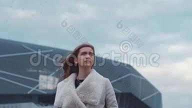 漂亮的欧洲年轻女孩穿着一件温暖的外套在机场闲逛。 很漂亮的女孩。 风的天气，风的嬉戏