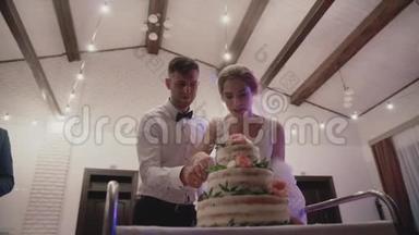 幸福的新娘和新郎切<strong>婚礼蛋糕</strong>，装饰鲜花的<strong>婚礼蛋糕</strong>。