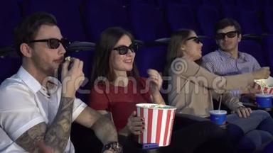 两对夫妇坐在电影院里吃爆米花