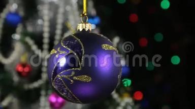 美丽的丁香新年和圣诞装饰球沉重地摆动在绳子上。