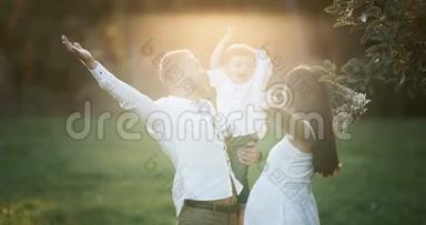 幼儿家庭：<strong>家长</strong>与幼儿儿子玩耍.. 快乐的爸爸妈妈抱着宝宝，在户外微笑