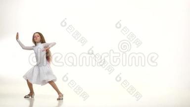 孩子们穿着漂亮的白色连衣裙在镶花地板上跳舞。 白色背景。 缓慢的一元