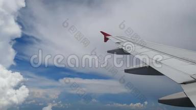 4K镜头飞机着陆飞行。 在白云和蓝天上空飞行的飞机的翅膀。 美丽的空中景色