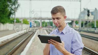 年轻人在火车站用平板电脑。 概念-网上机票，热爱旅游
