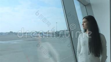 <strong>梦中的</strong>女孩站在窗户附近，带着飞机看着跑道