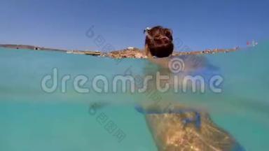 女孩在海滩背景下在海里洗澡。 女孩在蓝色的水里游泳。 水下射击。 马耳他