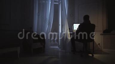 年轻的作家在夜间工作，在电脑上看剧本，在窗台上看猫