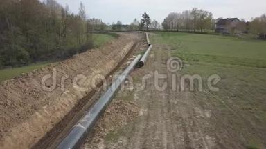 在青山之间铺设天然气管道。 大型高压钢管准备浸泡在开挖的沟槽中.. 土地工程