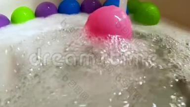 粉红色塑料球在浴缸里的水流中滚动，动作缓慢