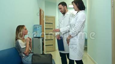 两位医生在<strong>医院大厅</strong>里和一位女病人谈话