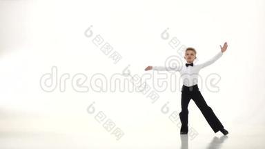 跳舞的小男孩优雅地旋转着动作。 白色背景。 缓慢的一元