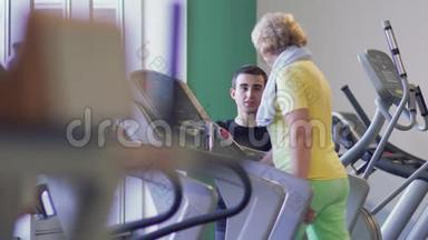 老年妇女在健身房跑步机上行走