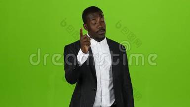 一个非洲国籍的人站着用手<strong>指责</strong>骂他的下属。 绿色屏幕