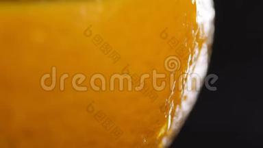 橙色外壳靠近黑色背景。 带有水滴的橙色。 宏观射击。 柑橘树上的水滴