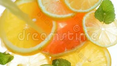 在装满柑橘类水果片和薄荷叶的罐子里倒入汁的特写慢动作视频