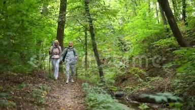 在树林里沿着<strong>小路散步</strong>的老夫妇