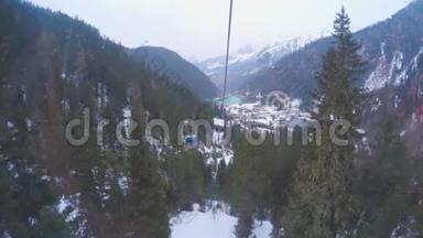 缆车在覆盖着白雪、森林的高山上穿梭索道