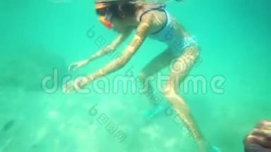 戴着水下面具的女孩在水下游泳，看着水下世界和热带<strong>小鱼</strong>