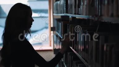 图书馆<strong>书架前</strong>一个女孩<strong>看书</strong>的剪影